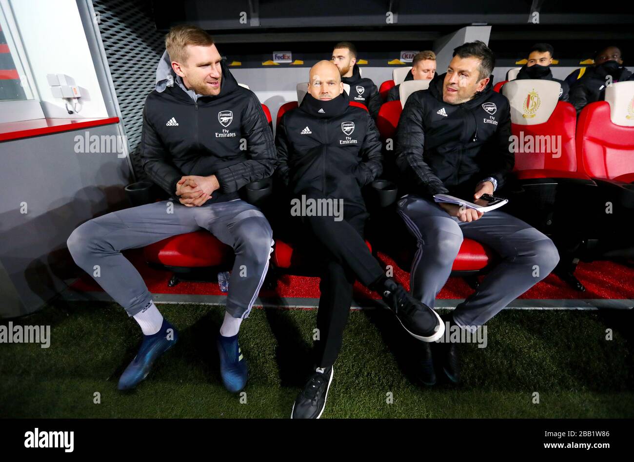 Freddie Ljungberg (centro), gerente interino del Arsenal y Per Mertesacker (izquierda) en el banco Foto de stock
