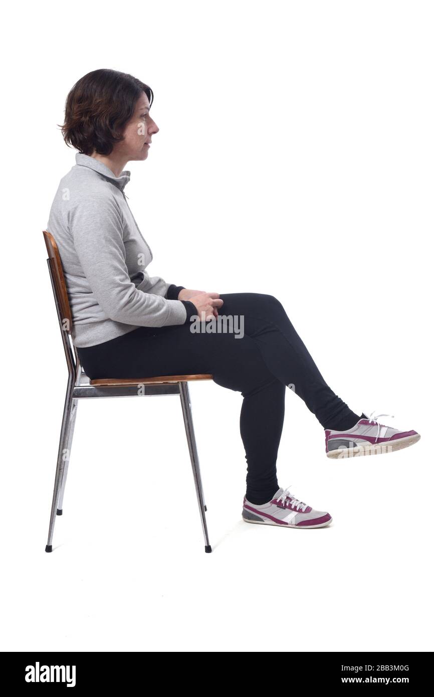 de una mujer sentada en una silla de mirando al lado y las piernas cruzadas Fotografía de stock -