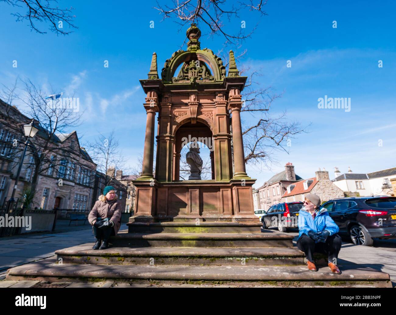 Haddington, East Lothian, Escocia, Reino Unido. 30 de marzo de 2020. Covid-19 el bloqueo del Coronavirus afecta a la ciudad normalmente bulliciosa en un hermoso día de primavera con calles vacías y distanciamiento social de la gente. Rosine y Linda se sientan a 2 m de distancia para una reunión. Trabajan para los Amigos del Viernes, que ofrece apoyo local a las personas con problemas de drogas y alcohol y están tratando de mantener el contacto con sus clientes Foto de stock