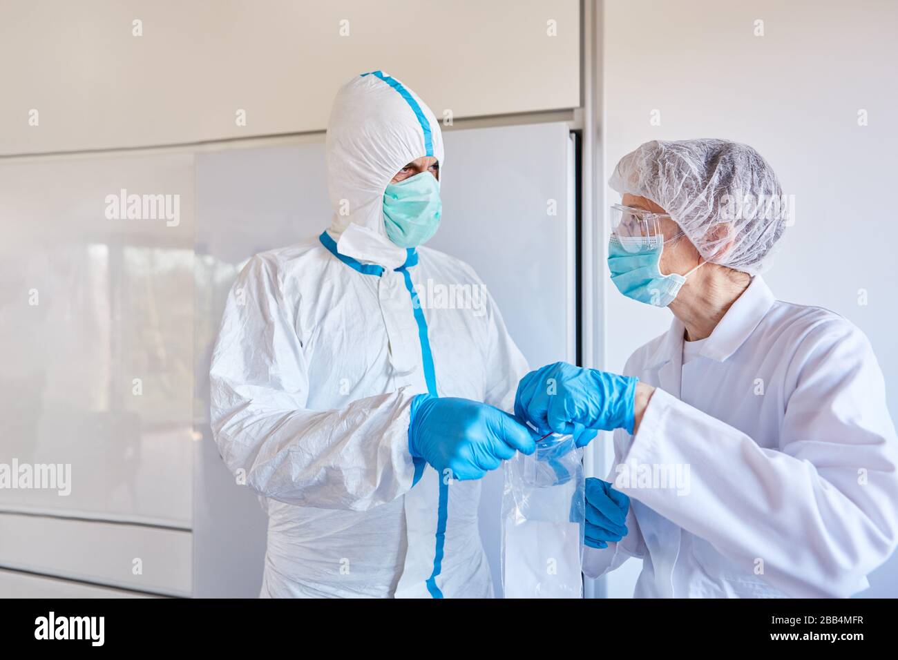 Los médicos examinan la muestra de saliva en la epidemia de coronavirus en el laboratorio para la detección de Sars-CoV-2 Foto de stock