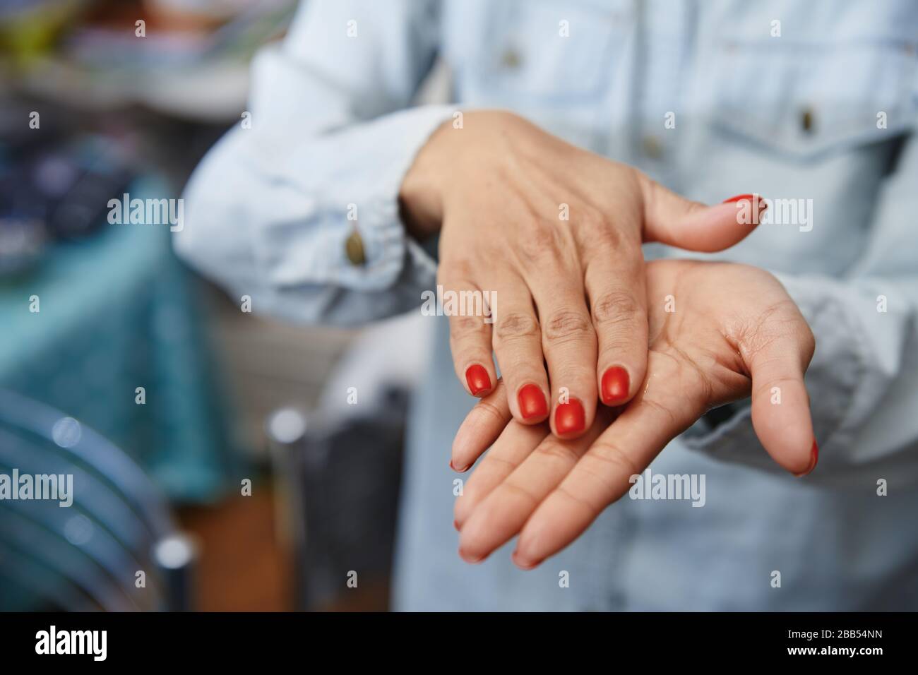 Mujer usando una loción hidratante para desinfección Foto de stock
