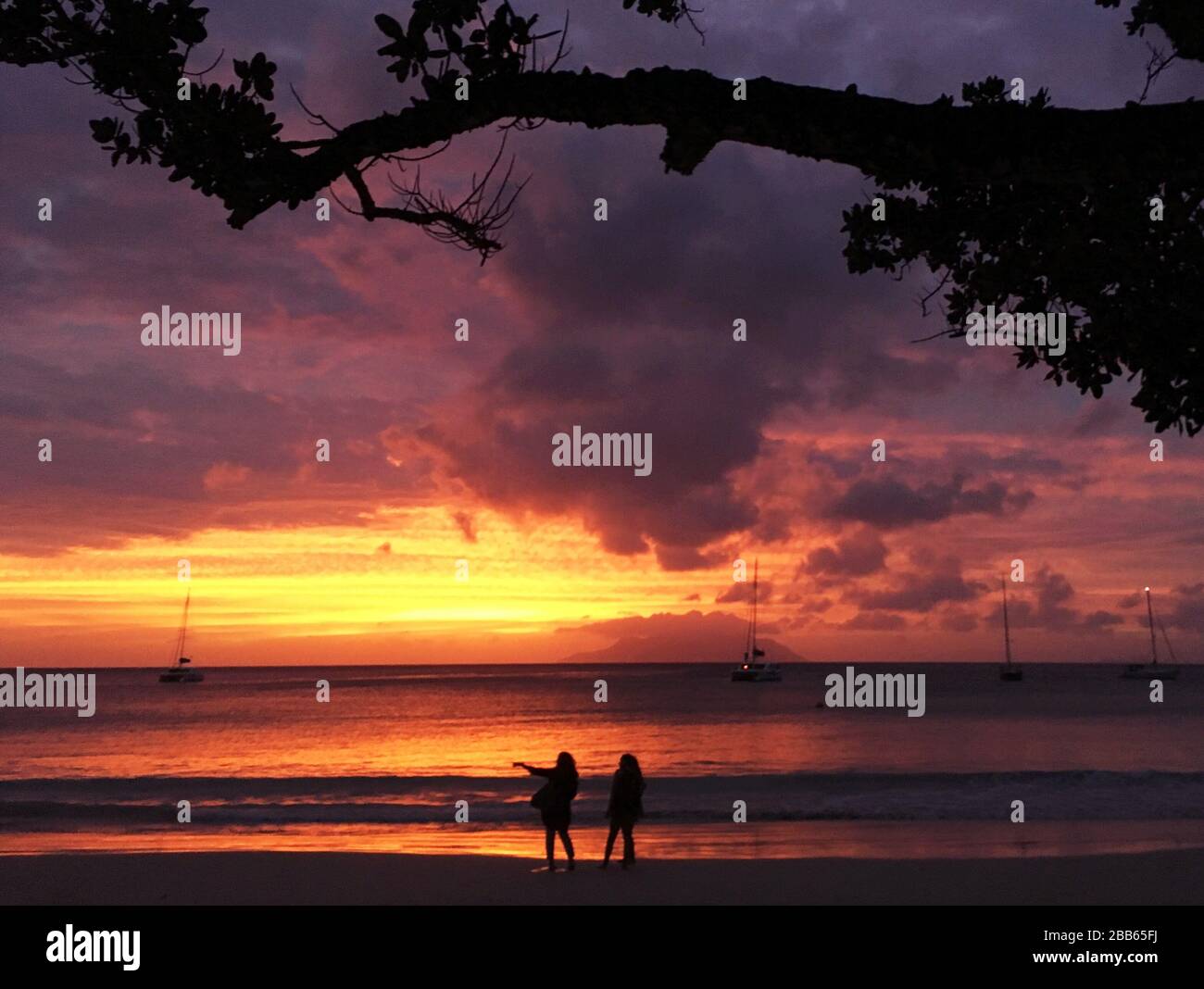 Silueta de dos personas en la playa al atardecer, Seychelles Foto de stock