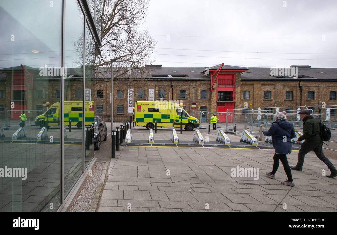 Londres, Reino Unido. 30 de marzo de 2020. Una foto tomada el 30 de marzo de 2020 muestra una ambulancia que llega al centro de exposiciones Excel y que se está transformando en un hospital de campo conocido como el NHS Nightingale Hospital London para ayudar con el brote de coronavirus en Londres, Gran Bretaña. El Servicio Nacional de Salud (NHS) ha invitado a tripulantes de dos de las mayores aerolíneas británicas a ofrecerse como voluntarios en un hospital de campo de 4,000 camas que está a punto de terminar en Londres para tratar a pacientes con coronavirus. Crédito: Han Yan/Xinhua/Alamy Live News Foto de stock