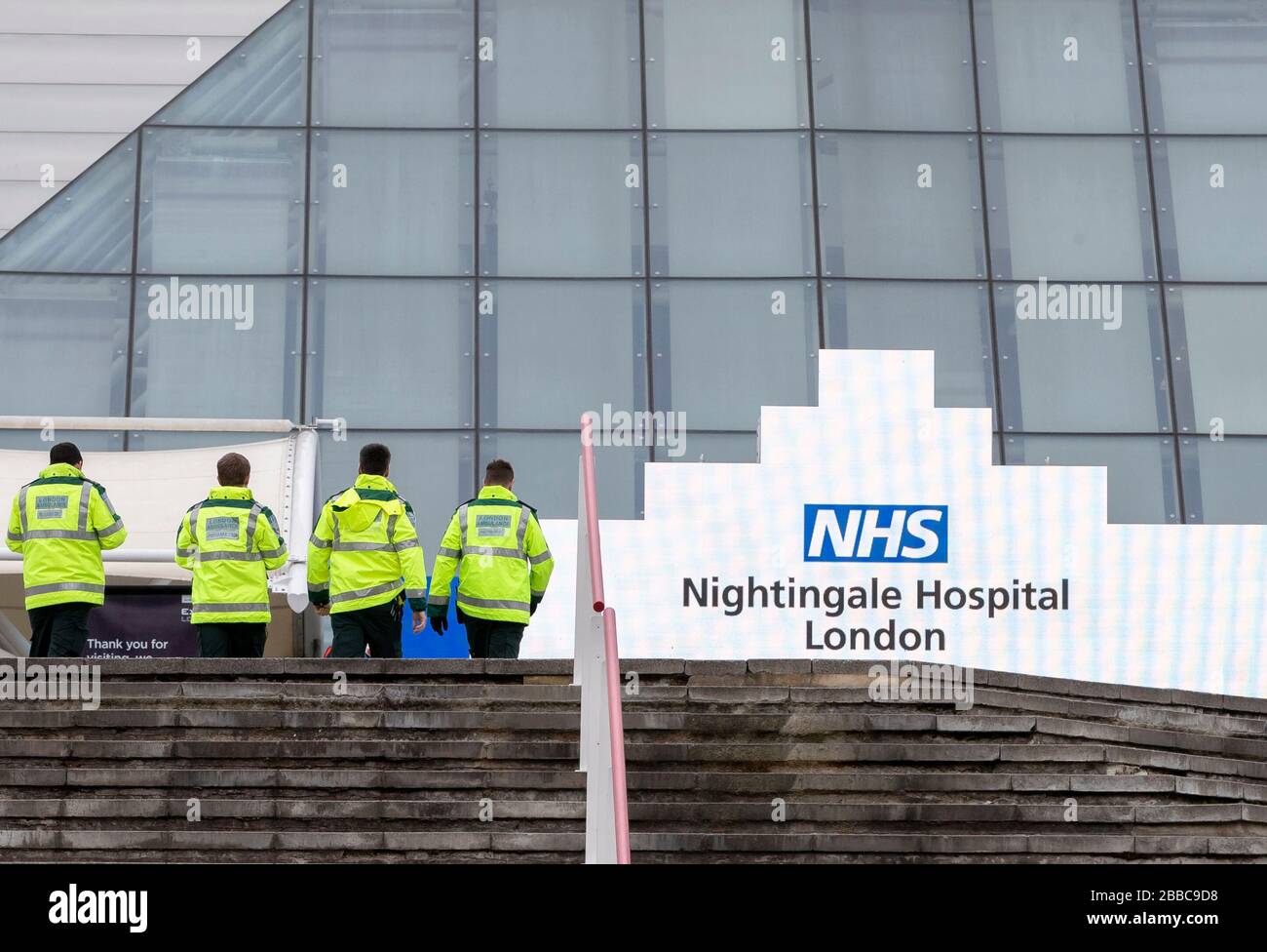 Londres, Reino Unido. 30 de marzo de 2020. La foto tomada el 30 de marzo de 2020 muestra a los paramédicos de ambulancia que caminan en el centro de exposiciones Excel que se está transformando en un hospital de campo conocido como el NHS Nightingale Hospital London para ayudar con el brote de coronavirus en Londres, Gran Bretaña. El Servicio Nacional de Salud (NHS) ha invitado a tripulantes de dos de las mayores aerolíneas británicas a ofrecerse como voluntarios en un hospital de campo de 4,000 camas que está a punto de terminar en Londres para tratar a pacientes con coronavirus. Crédito: Han Yan/Xinhua/Alamy Live News Foto de stock