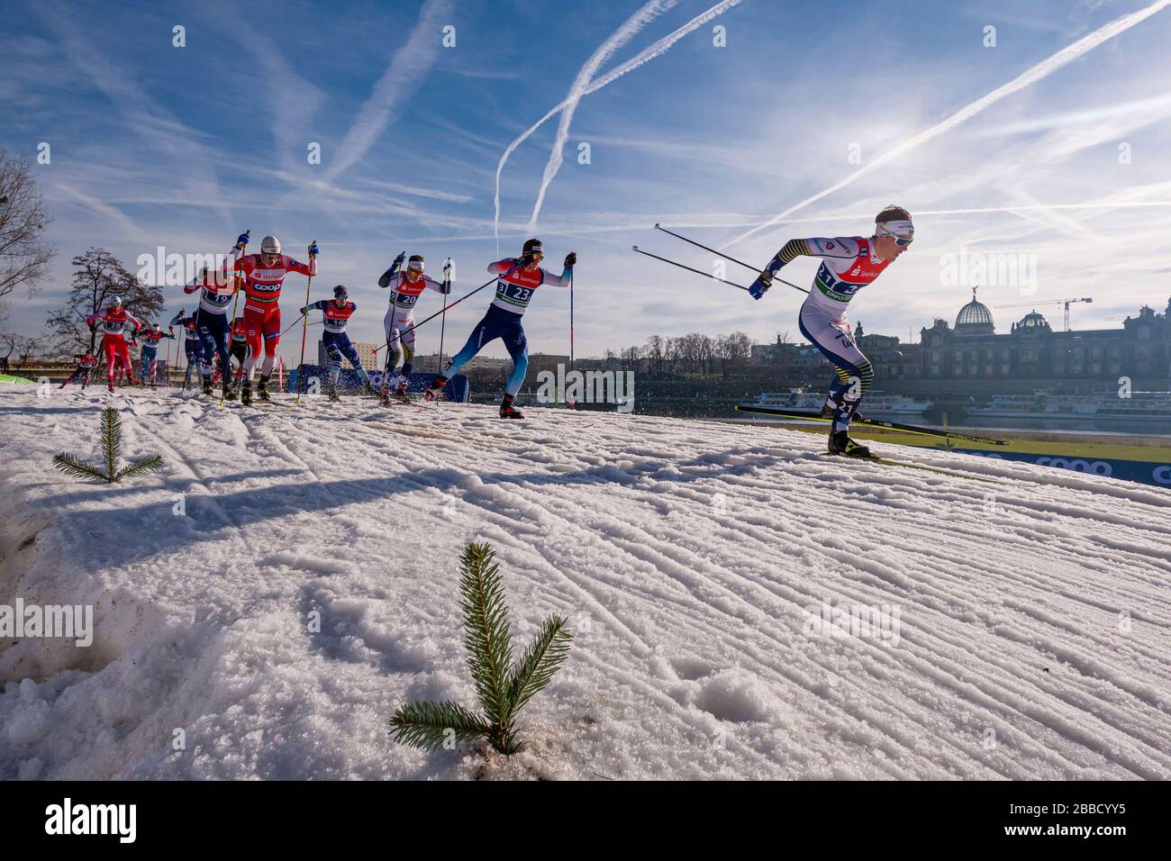 Hombres corriendo en la FIS esquí de fondo sprint World Cup a orillas del río Elba, el horizonte de la ciudad barroca en la distancia Foto de stock