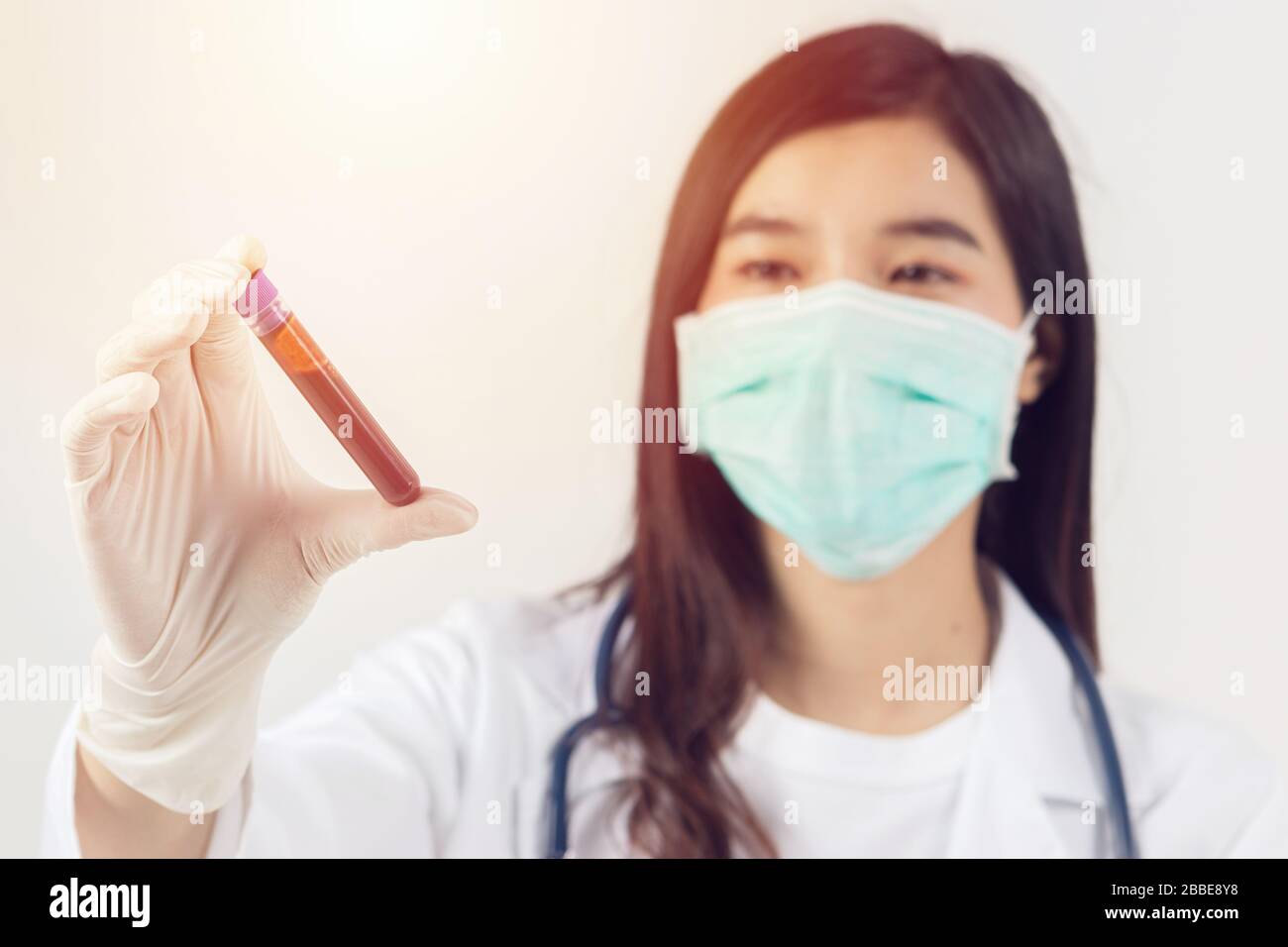 Muestra de sangre de coronavirus. Médico asiático sosteniendo tubo de prueba con sangre para análisis de covid-19. Análisis de laboratorio para análisis e inventar drogas y vacci Foto de stock