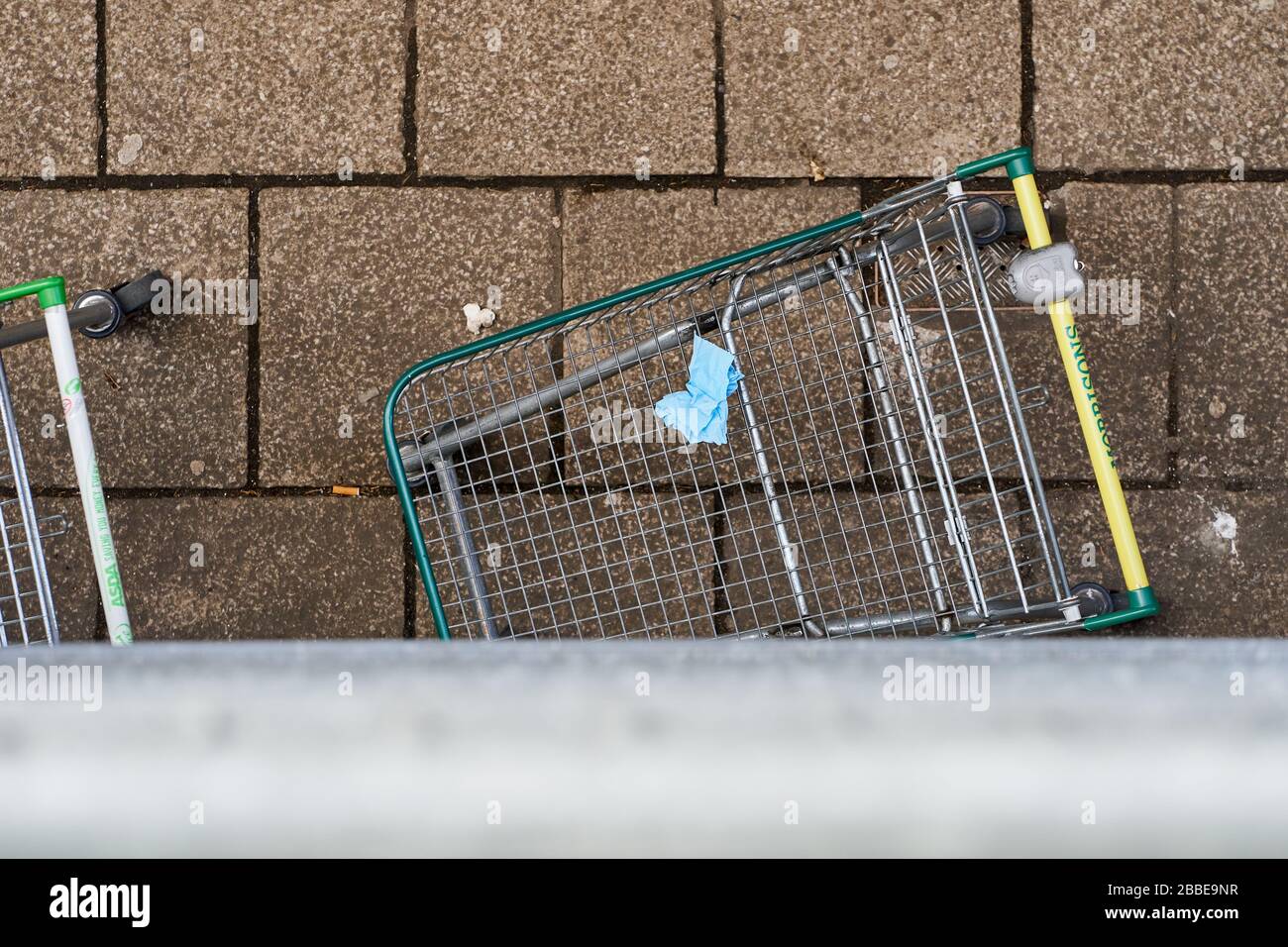 Durante el brote de la enfermedad de Coronavirus (COVID-19), los compradores del Reino Unido dejan guantes y tejidos en carritos y cestas de compras descartados. Foto de stock