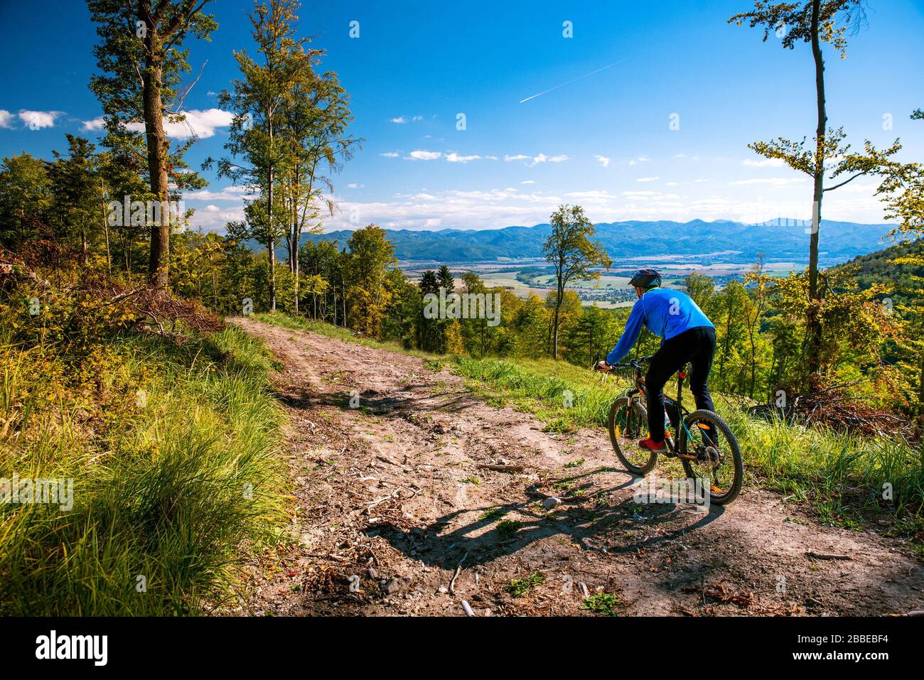 Bicicleta de montaña hombre montar cuesta abajo en bicicleta en otoño montañas bosque paisaje. Actividad deportiva al aire libre. Naturaleza colorida. Foto de stock