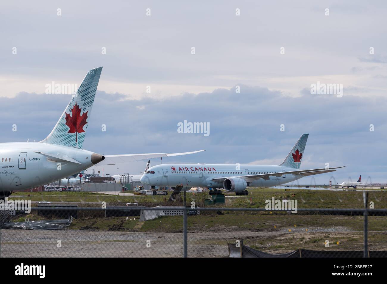RICHMOND, BC, CANADA - 29 DE MARZO de 2020: Air Canada 787 Dreamliner estacionado en el asfalto con otros aviones en el fondo durante una reducción global en Foto de stock