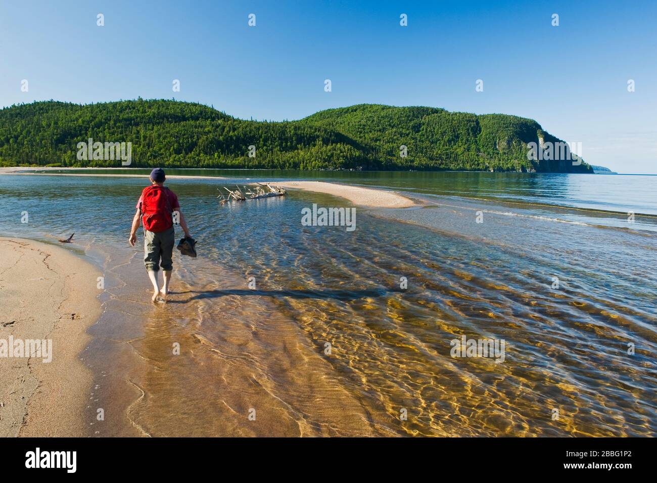 Excursionista a lo largo de la playa en Old Woman Bay, Lake Superior Provincial Park, Ontario, Canadá Foto de stock