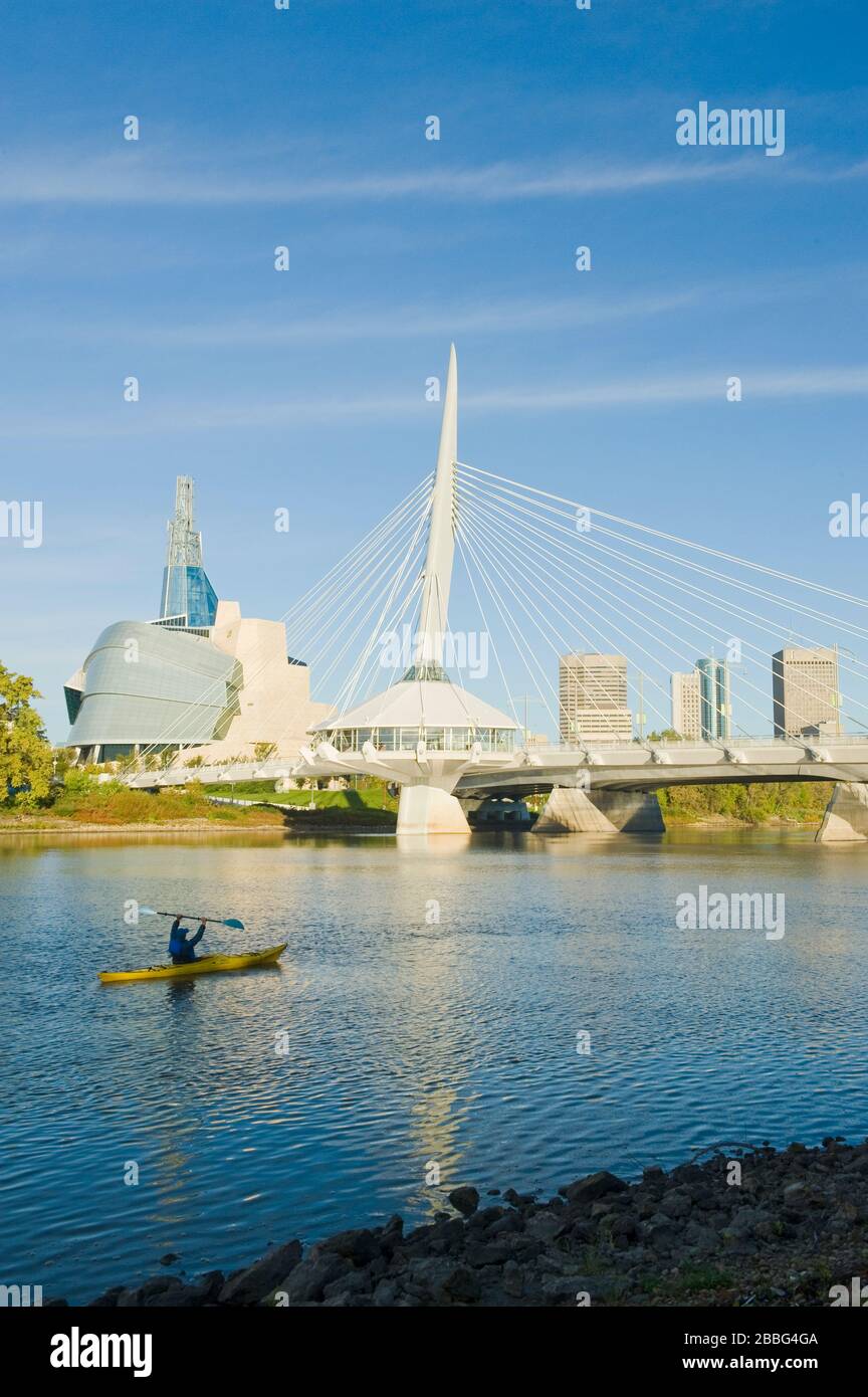 Kayak, el horizonte de Winnipeg desde St. Boniface mostrando el Río Rojo, el Puente Esplanade Riel y el Museo Canadiense de Derechos Humanos, Manitoba, Canadá Foto de stock