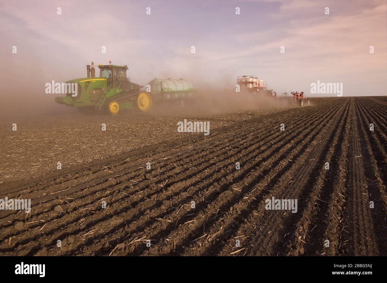 Movimiento del tractor y de la sembradora de siembra de aire sembrando grano en condiciones muy secas, Manitoba, Canadá Foto de stock