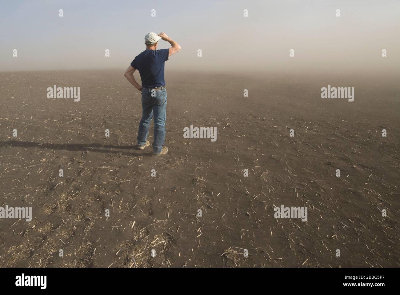 Un agricultor en un campo asolado por la sequía con suelo de la parte superior que causa erosión del suelo, Tiger Hills, Manitoba, Canadá Foto de stock