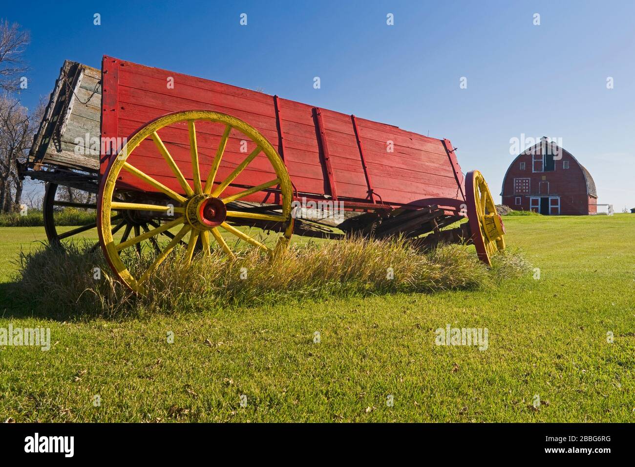 Granero rojo y vagón viejo, cerca de Woseley, Saskatchewan, Canadá Foto de stock