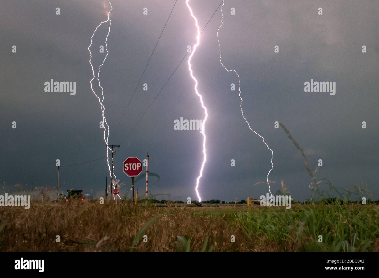 Tormenta con relámpagos sobre un campo rural en Oklahoma Estados Unidos 4 imagen fusionada incliudando un rayo golpeando un poste de poder. Foto de stock