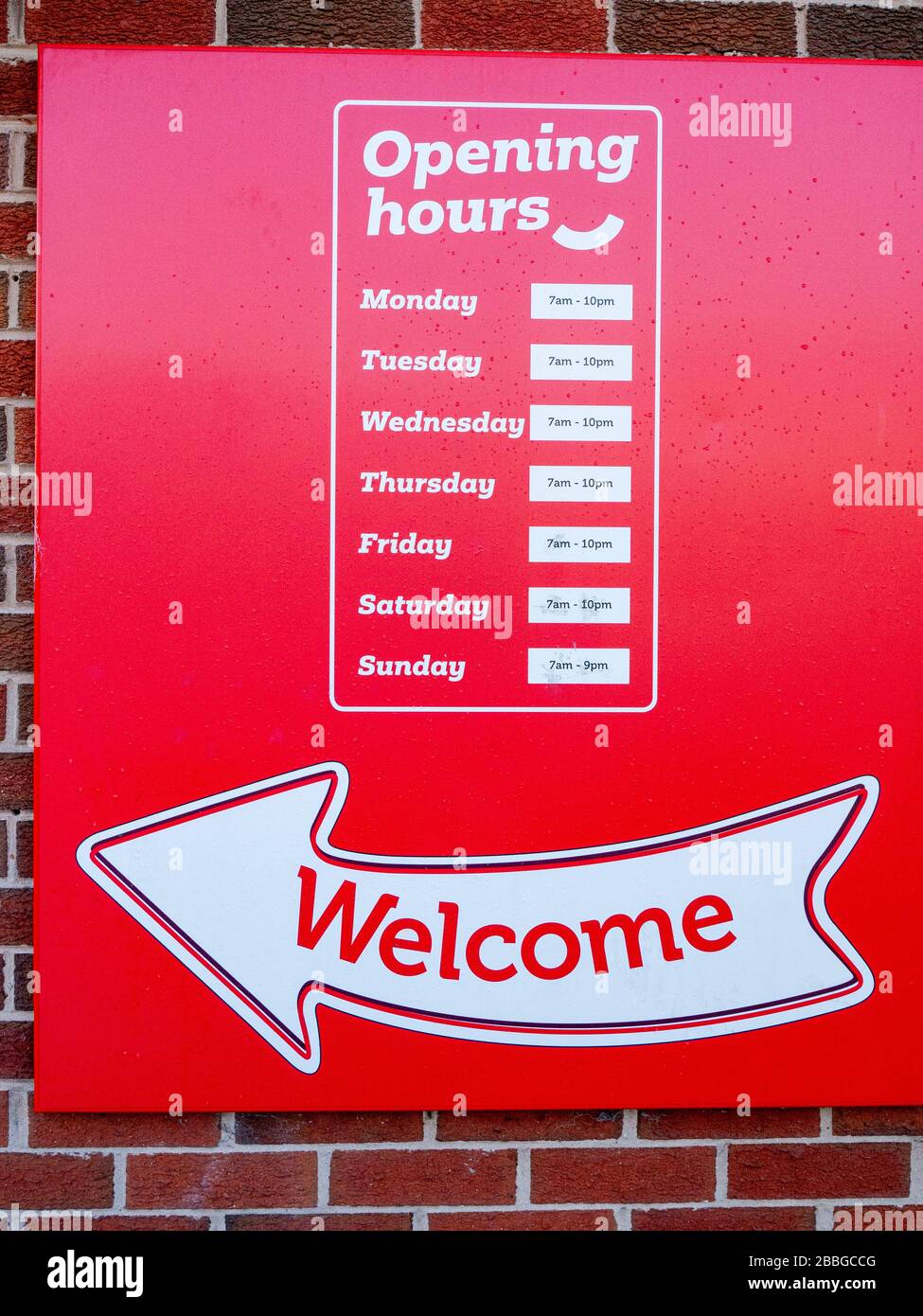 Rojo bienvenida horas de apertura letrero fuera de la pared Reino Unido Foto de stock