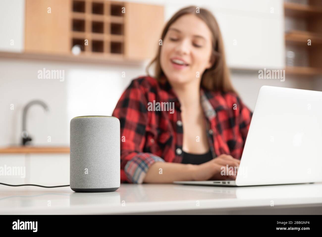 Mujer hablando con un altavoz inteligente. Asistente inteligente en sistema de hogar inteligente. Foto de stock