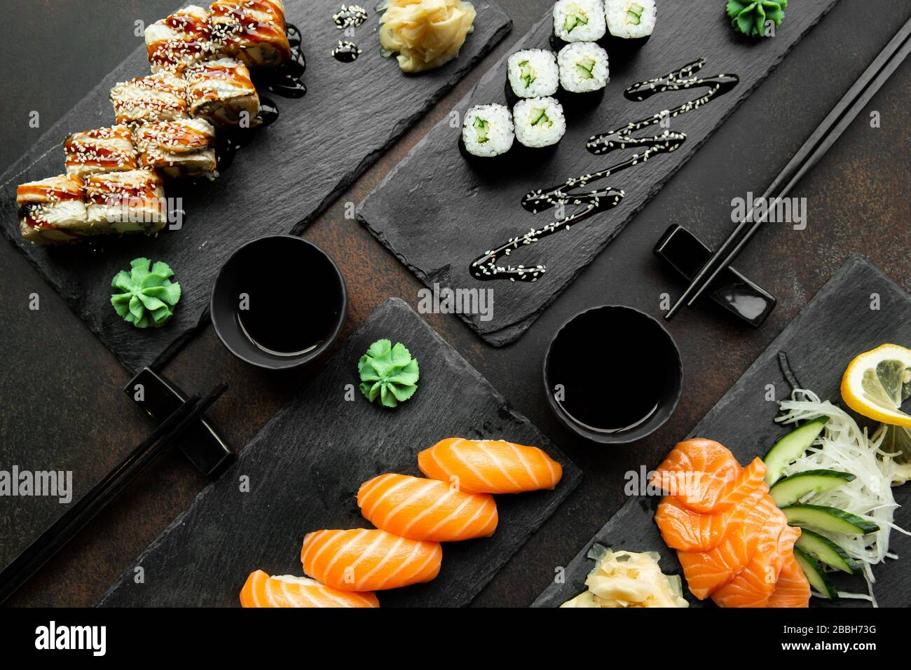 sushi japonés. Varios tipos de sushi servido en platos de cerca. Un gran conjunto de panecillos en un plato en un restaurante. Foto de stock