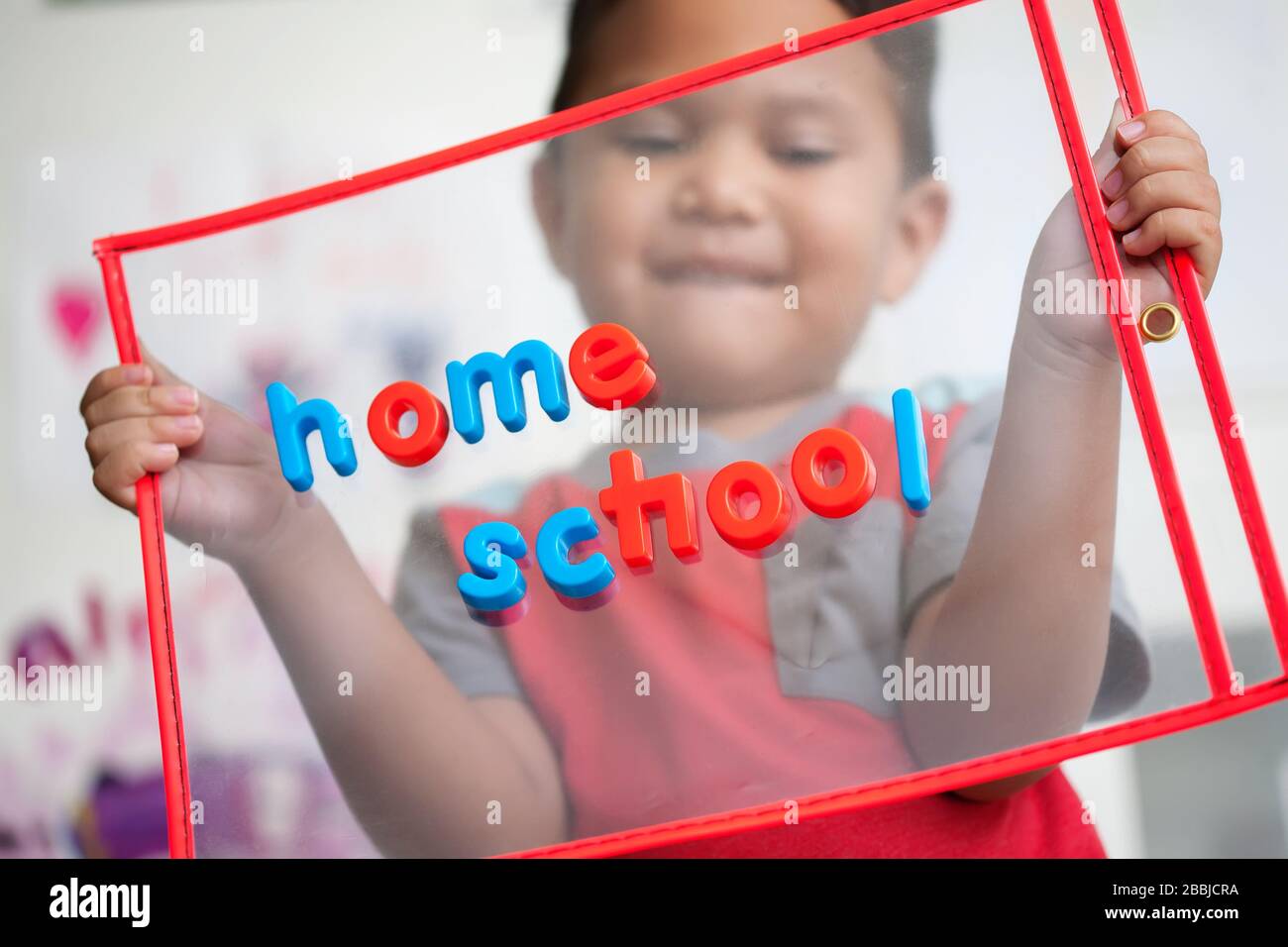 Un niño de 4 años con una sonrisa en la cara está feliz de comenzar la escuela en casa. Foto de stock
