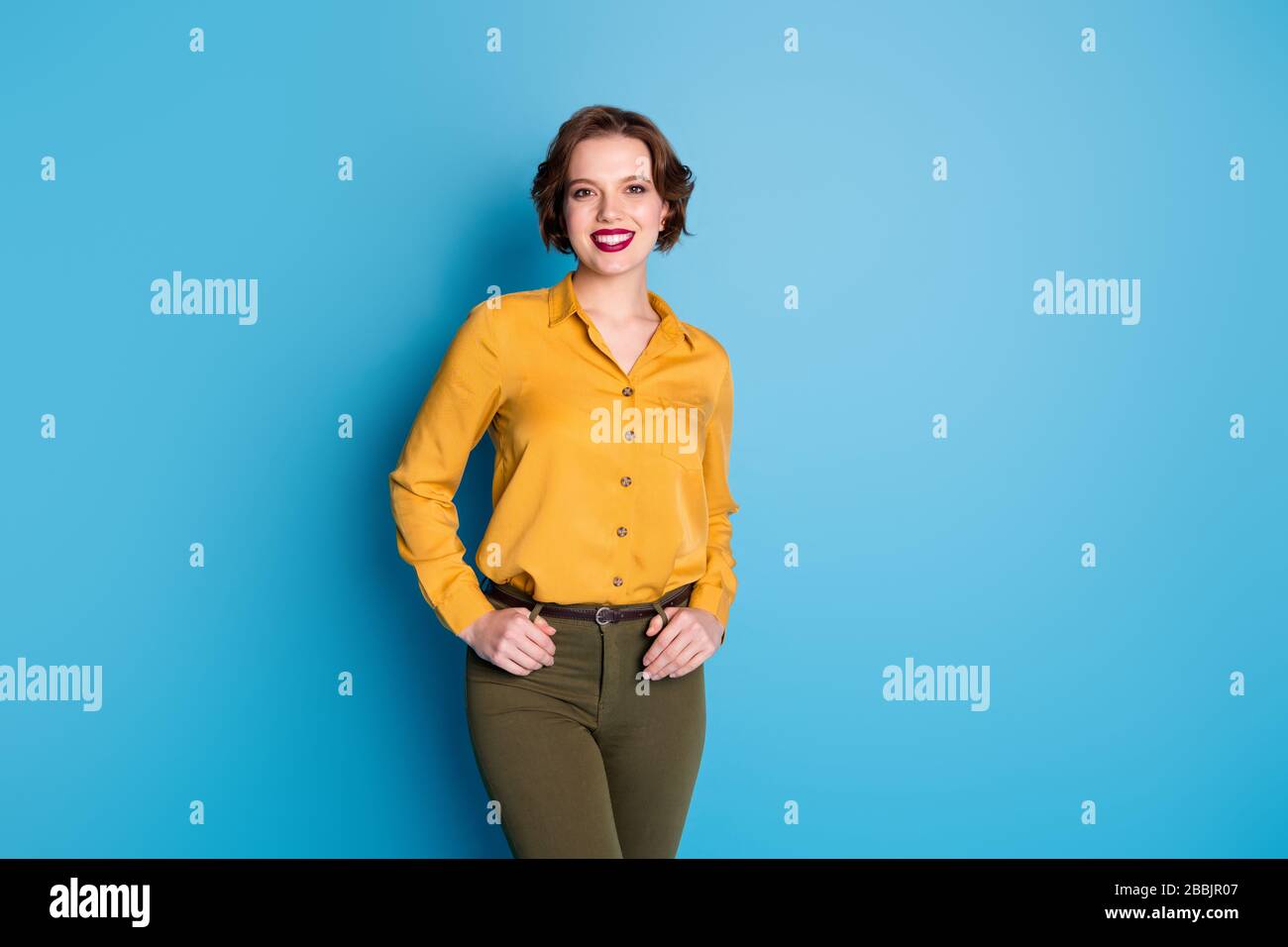 Foto de la señora de negocios bonita increíble auto-confianza sonrisa  trabajador fiable persona llevar camisa amarilla verde pantalones aislados  fondo de color azul brillante Fotografía de stock - Alamy