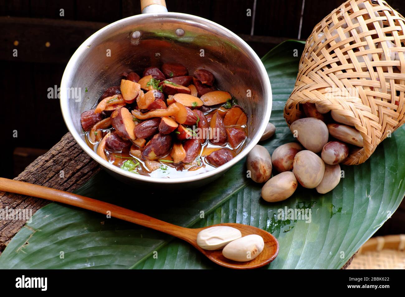 Primer plano olla de semillas de jackfruit cocinar con salsa y especias y  materia prima sobre fondo de madera oscura, comida vegetariana casera  vietnamita de la nuez para la Veja Fotografía de