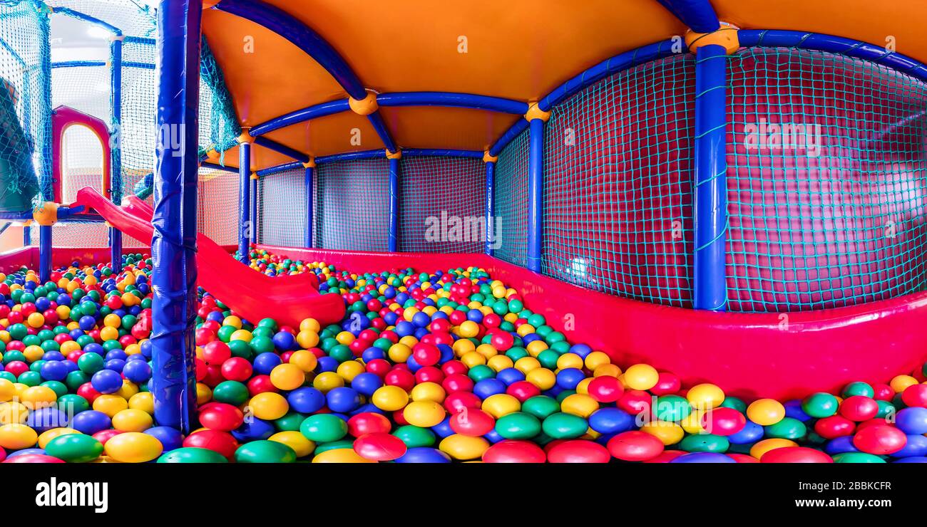 sala de juegos para niños con coloridas bolas y un tobogán de plástico. .  Panorámica amplia Fotografía de stock - Alamy