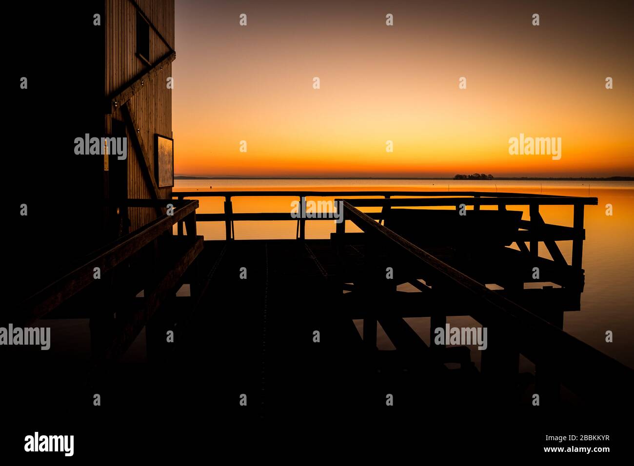 Winzlar, Alemania. 1 de abril de 2020. El cielo sobre un mirador en el Steinhuder Meer brilla en naranja poco antes del amanecer. Crédito: Moritz Frankenberg/dpa/Alamy Live News Foto de stock