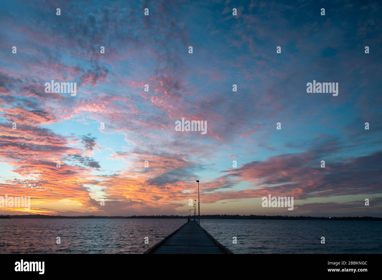 Ardiente puesta de sol sobre el río Swan, Perth Australia Occidental. Una escena idílica con un paisaje nublado espectacular Foto de stock