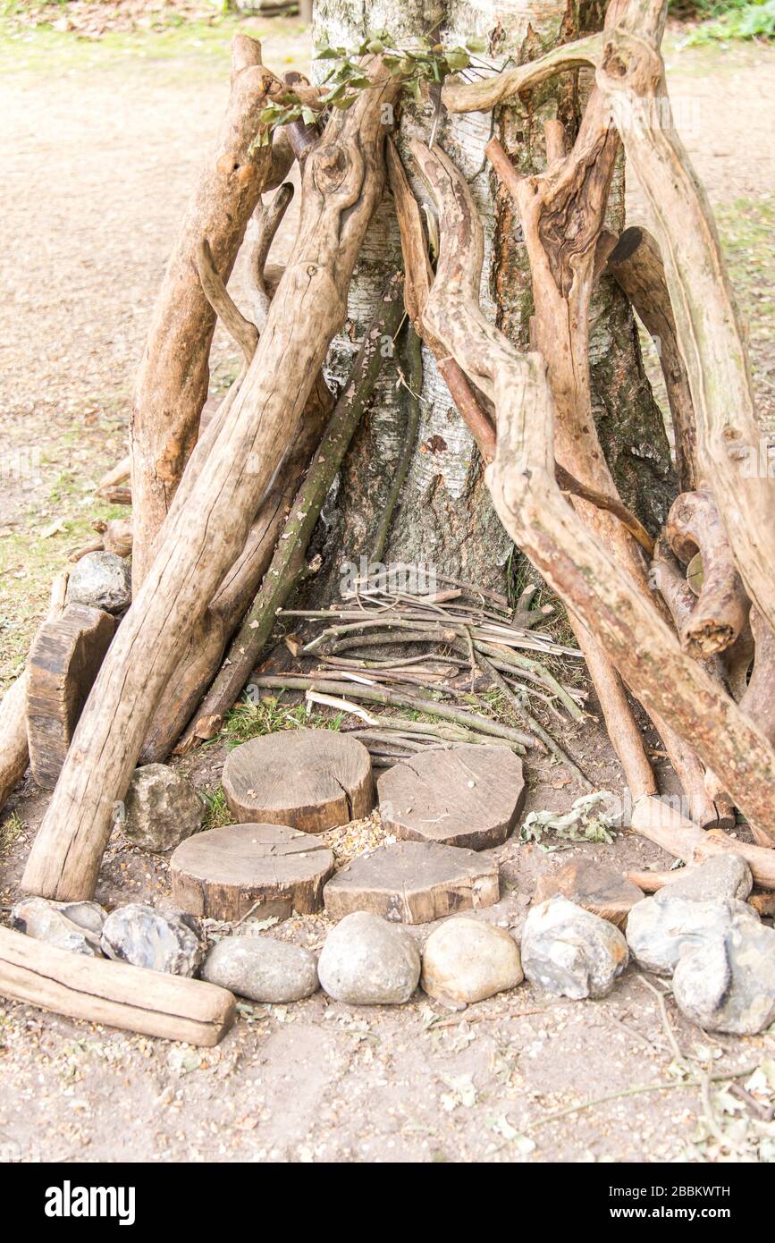 Den de madera hecho por niños con troncos y piedras. Actividades al aire libre para niños. Inglaterra Reino Unido Foto de stock