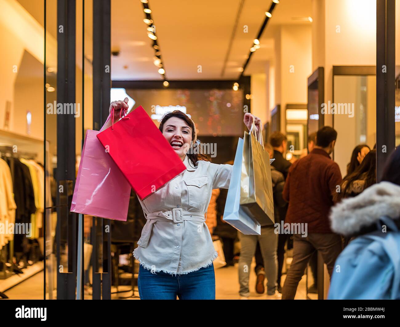 Hermosa mujer en ropa de moda deja una tienda con las bolsas de  compras.Mujer saliendo de ropa shop.Shopping, concepto de estilo de vida  Fotografía de stock - Alamy