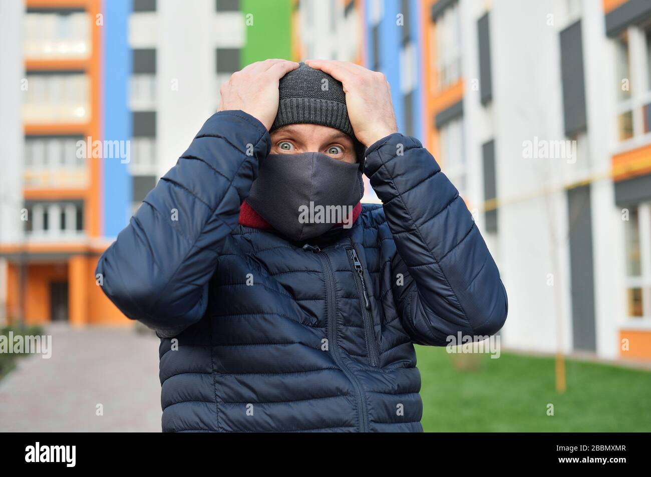 Pánico coronavirus. Hombre con una máscara en su rostro en la ciudad pánico por las malas noticias sobre el virus de la corona Foto de stock