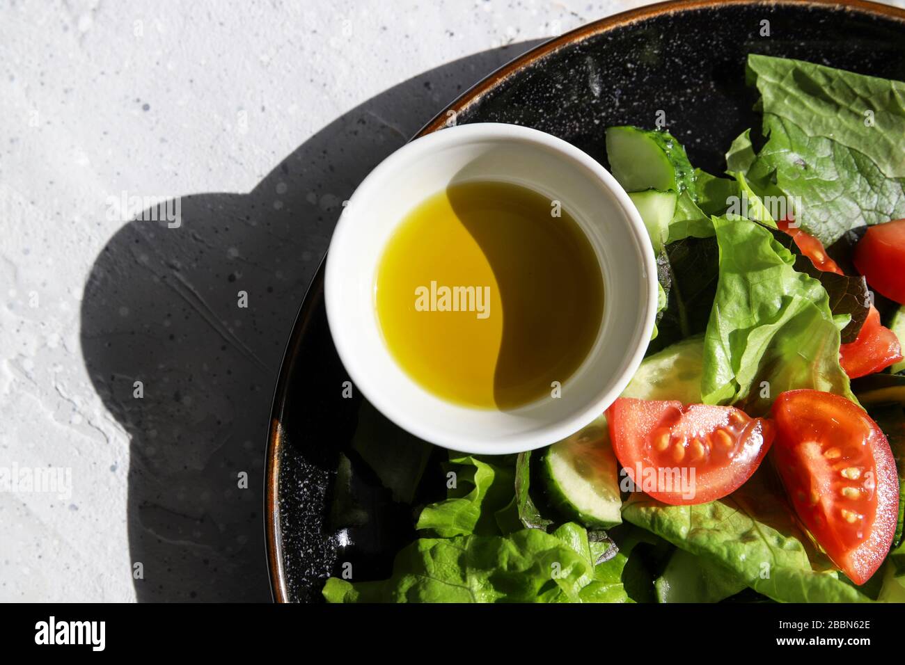 Ensalada de desintoxicación fresca de verano con tomates, pepino, lechuga romana y aceite de oliva. Dieta saludable para veganos o vegetarianos, vista superior, espacio de copiado Foto de stock