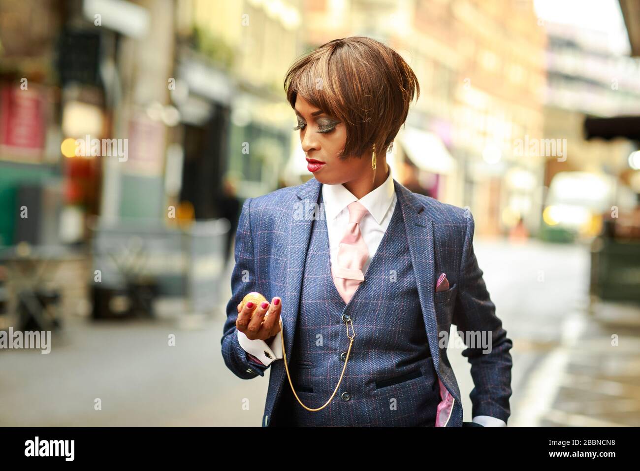 una mujer joven que comprueba su reloj de bolsillo vestido con un traje de  tweed Fotografía de stock - Alamy