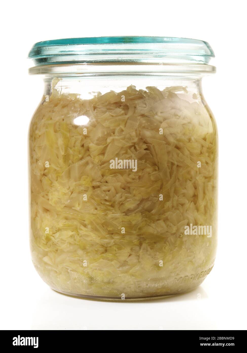 Sauerkraut fresco crudo en un vaso sobre fondo blanco Foto de stock