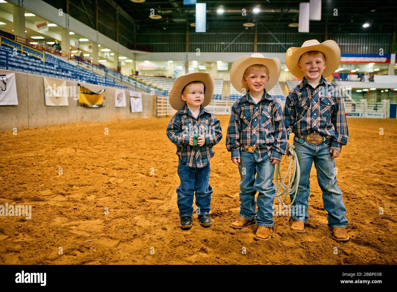 Lima raíz Plaga Retrato de tres niños sonriendo vestidos de vaqueros en una arena de rodeo  Fotografía de stock - Alamy
