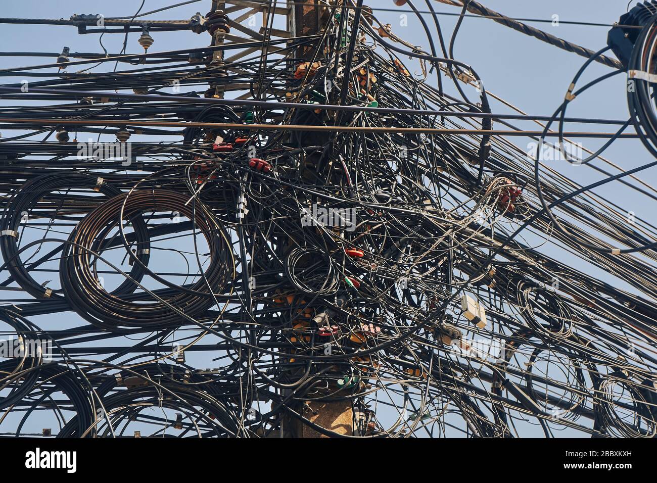 Muchos cables eléctricos enredados juntos contra un cielo azul Fotografía  de stock - Alamy