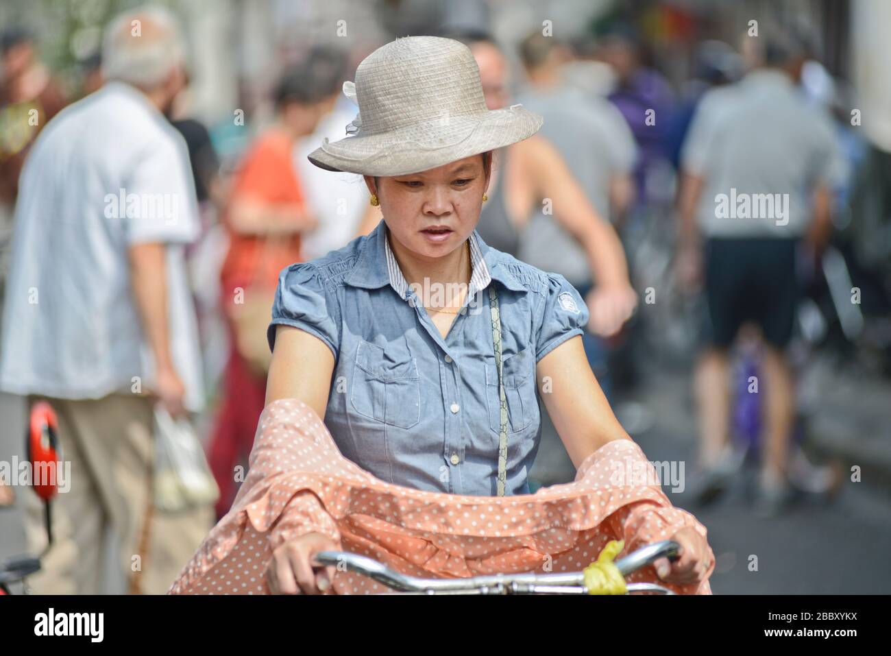 Mujer China montando en bicicleta en Penglai Road, Huangpu, Shanghai Foto de stock
