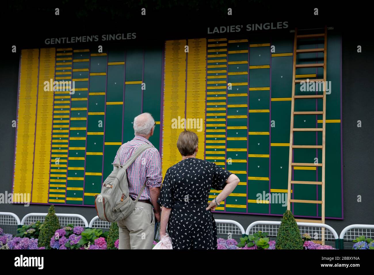 Londres, Reino Unido. 9 de julio de 2019. La foto del archivo tomada el 9 de julio de 2019 muestra a la gente mirando el orden de juego durante el día 8 del Campeonato de Tenis de Wimbledon 2019 en Londres, Gran Bretaña. El Wimbledon de este año ha sido cancelado debido a las preocupaciones de salud pública relacionadas con la actual pandemia de COVID-19, anunció el All England Club (AELTC) después de una reunión de emergencia el miércoles. Crédito: Han Yan/Xinhua/Alamy Live News Foto de stock
