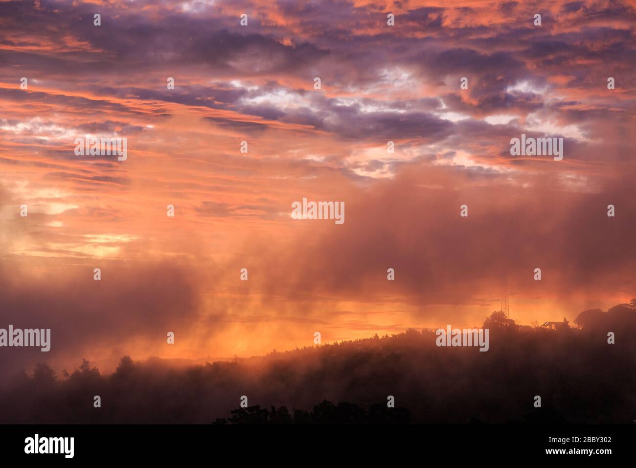 Nubes coloridas al atardecer sobre la ciudad de Santa Elena, puerta de entrada a los bosques nubosos del centro de Costa Rica y la famosa Reserva del Bosque Nuboso Monteverde. Foto de stock