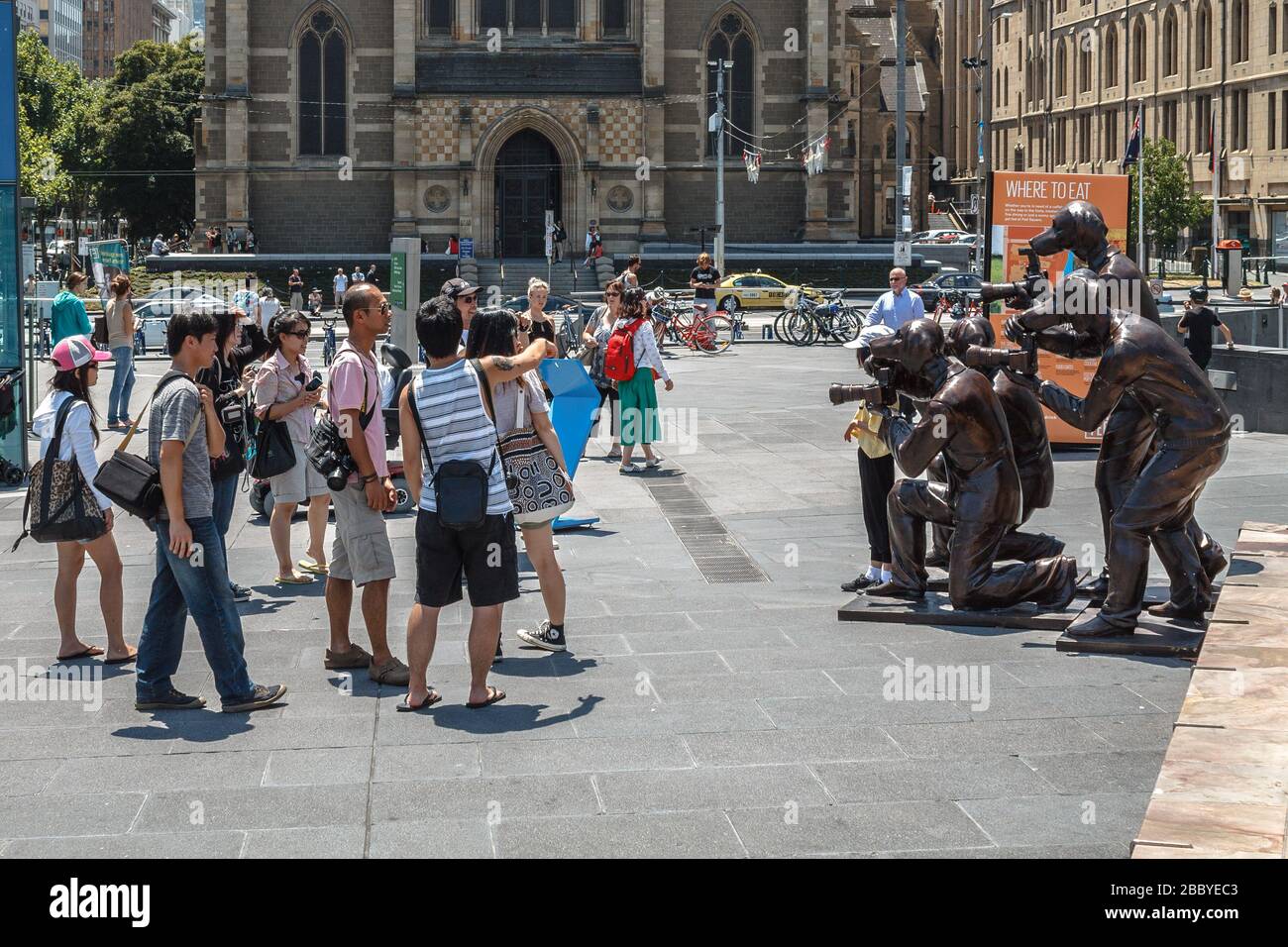 Turistas mirando la escultura Paparazzi Dogs en Federation Square, Melbourne Foto de stock