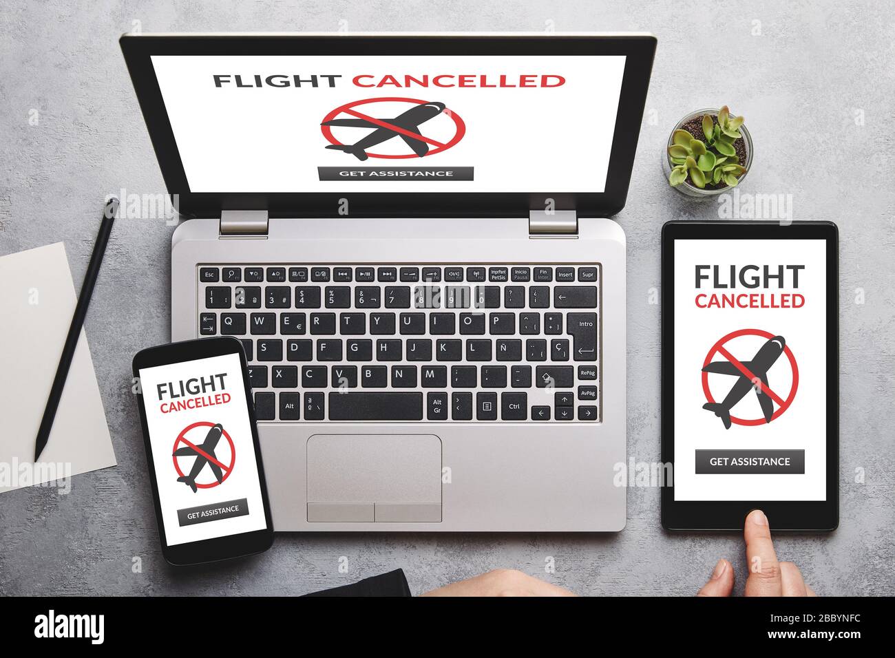 Concepto de vuelo cancelado en la pantalla del portátil, tablet y smartphone sobre una mesa gris. Disposición plana Foto de stock