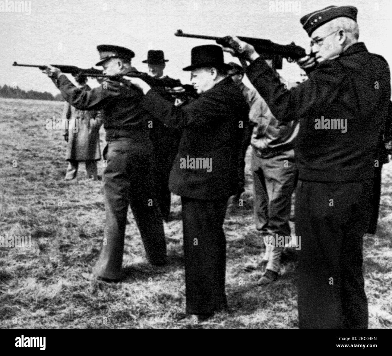 Winston Churchill probando la nueva carabina americana en un campo de tiro. Con él: Omar Bradley y el general Eisenhower. Marzo 1944 Foto de stock
