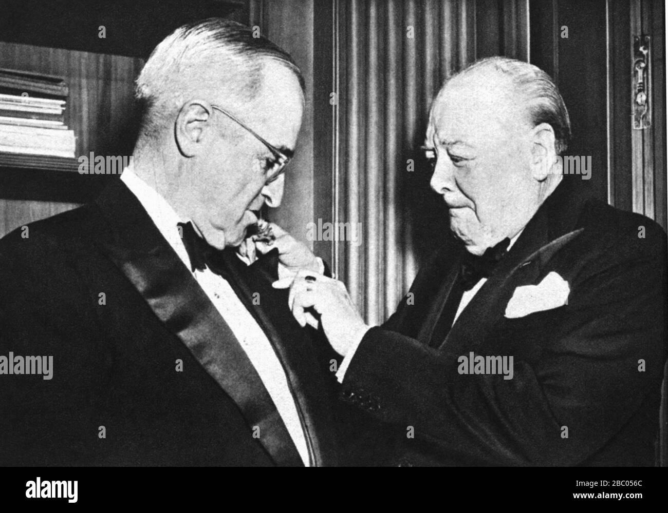 Churchill clavando un agujero en la chaqueta de cena del presidente Truman en una cena para el presidente de la embajada británica. Washington, 8 de enero de 1953 Foto de stock
