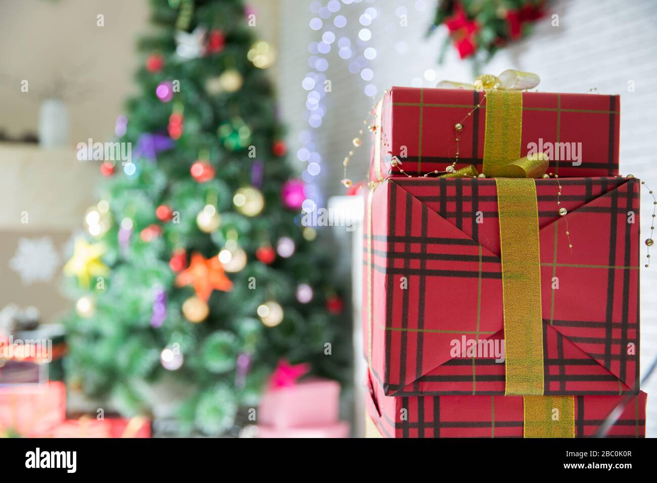 cajas de regalo en árbol de navidad. feliz año nuevo. celebrar navidad en  casa. compras de invierno de vacaciones. ventas de compras. entrega de  regalos. Rojo, rosa, plata Fotografía de stock -