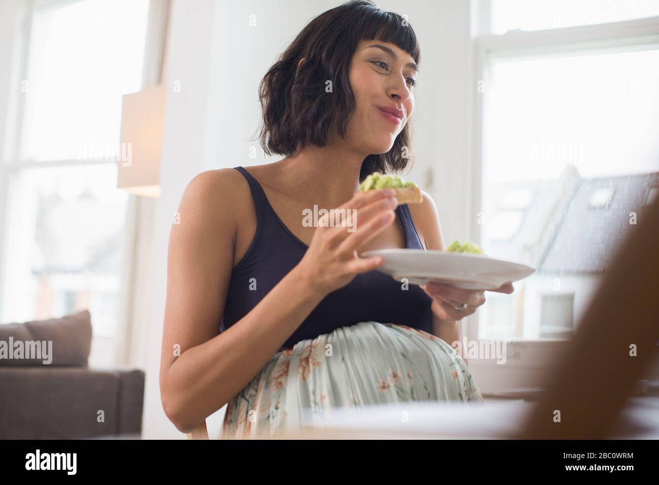Mujer embarazada feliz comiendo Foto de stock