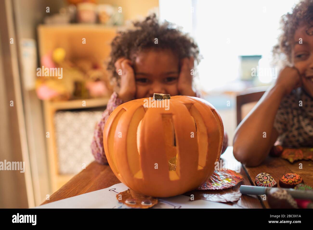 Retrato linda chica tallando calabaza de Halloween en la mesa Foto de stock