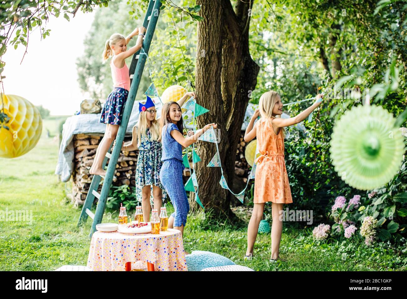 Niñas que adornan el jardín para una fiesta de cumpleaños Foto de stock