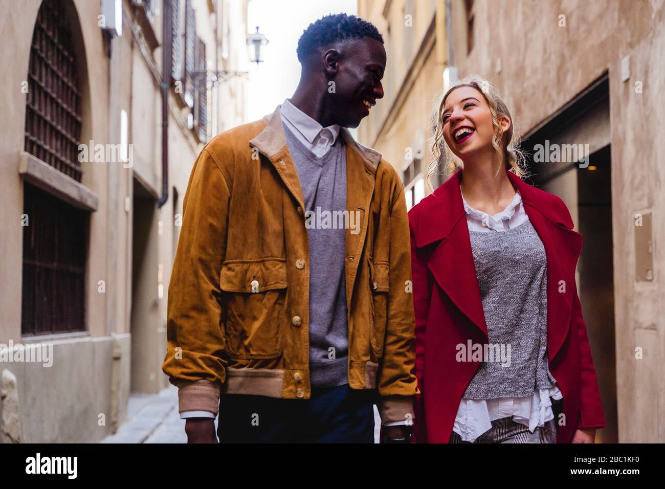 Feliz pareja joven paseando por un callejón en la ciudad de Florencia, Italia Foto de stock