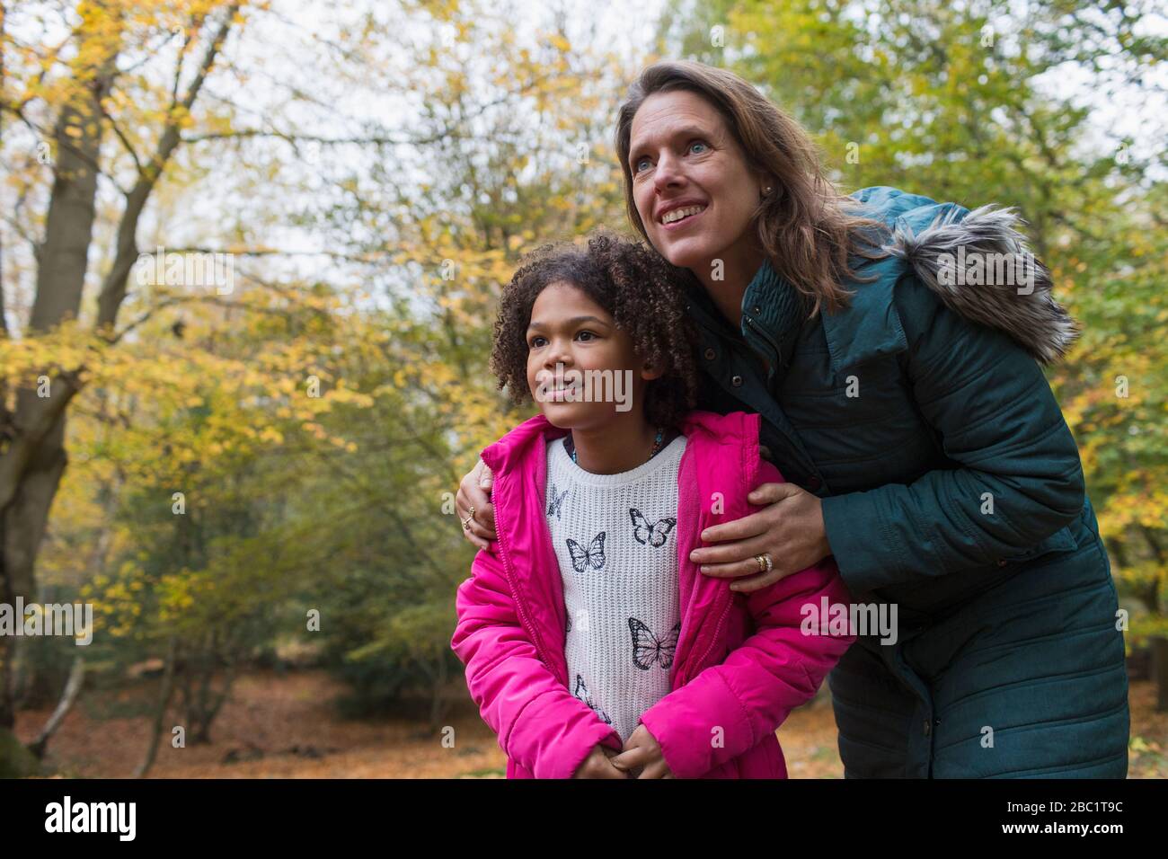 Madre e hija curiosa en los bosques otoñales Foto de stock