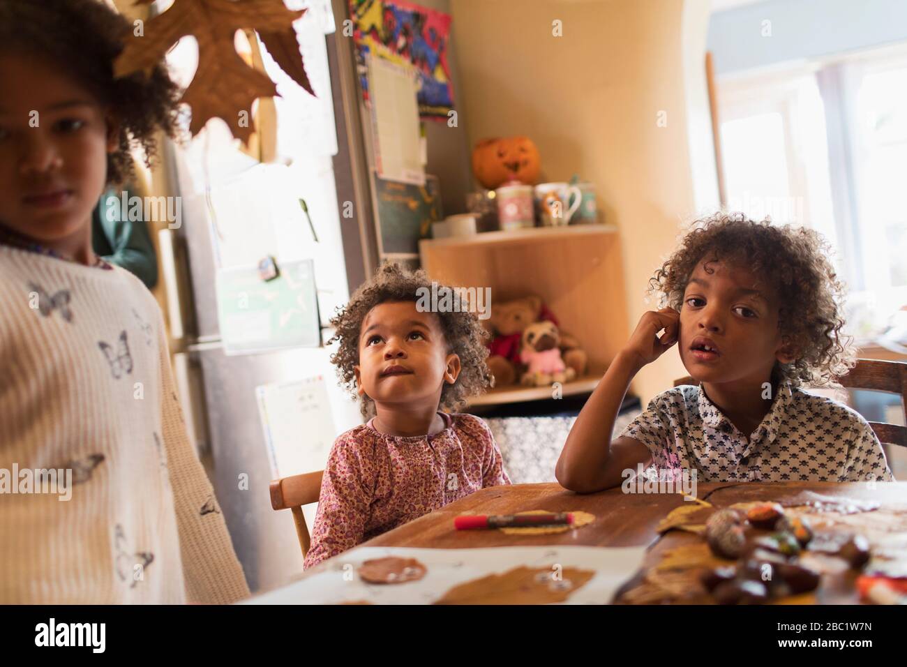 Hermanos y hermanas haciendo artesanías de otoño en la mesa Foto de stock
